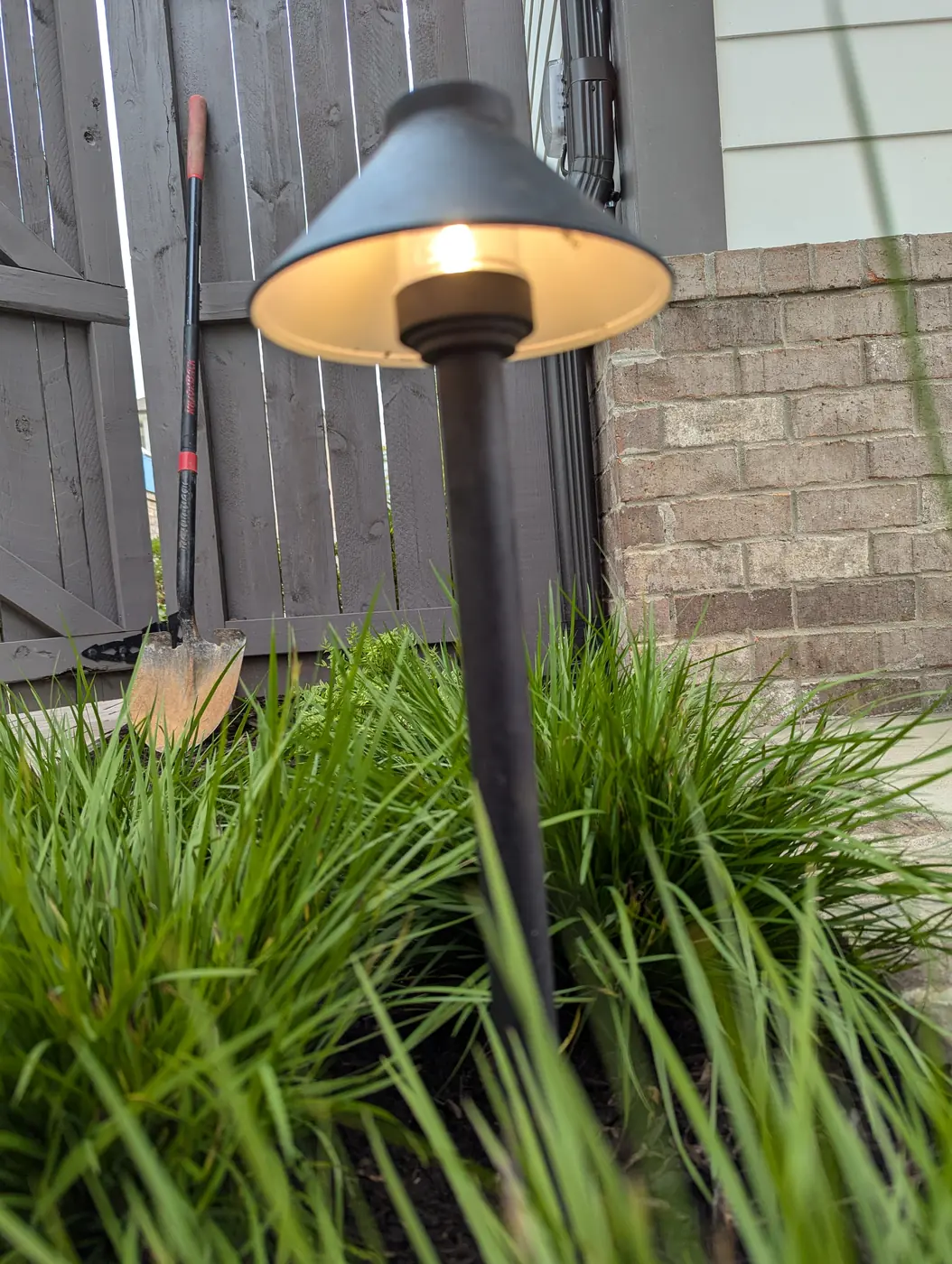 Close-up of a black low-voltage path light among ornamental grasses in Nashville, TN