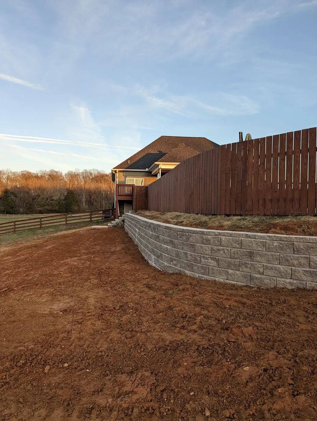 Block retaining wall along a fence line at sunset in Nashville, TN