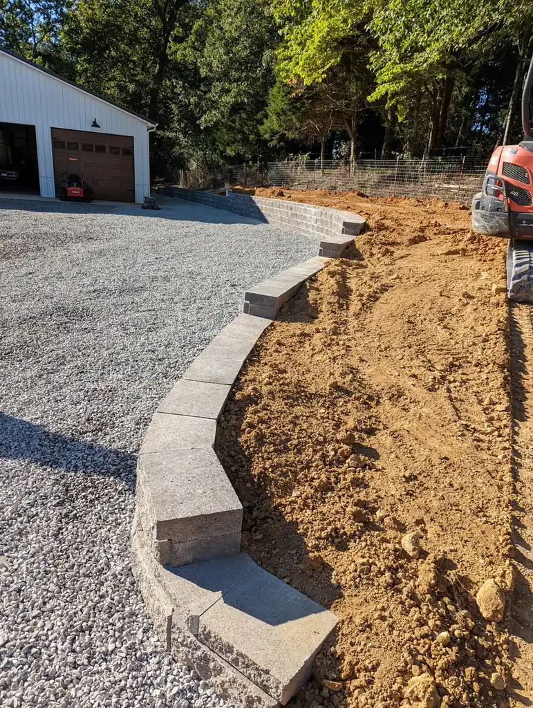 Block retaining wall under construction along a gravel driveway in Nashville, TN