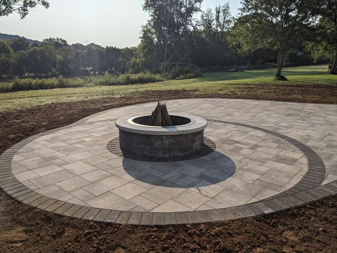 Circular paver patio with a stone fire pit on a freshly graded lot in Nashville, TN