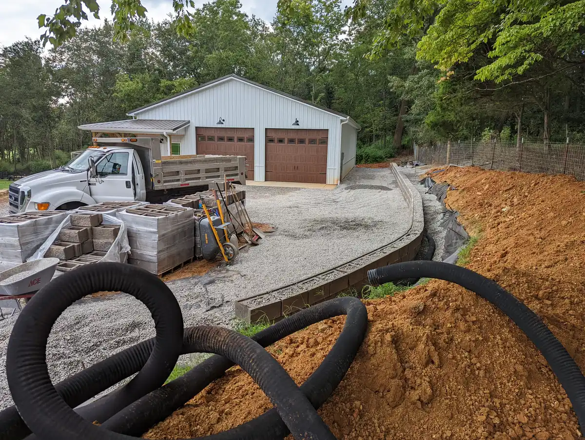 Corrugated drain pipe and wall block staged at a gravel driveway drainage project in Nashville, TN