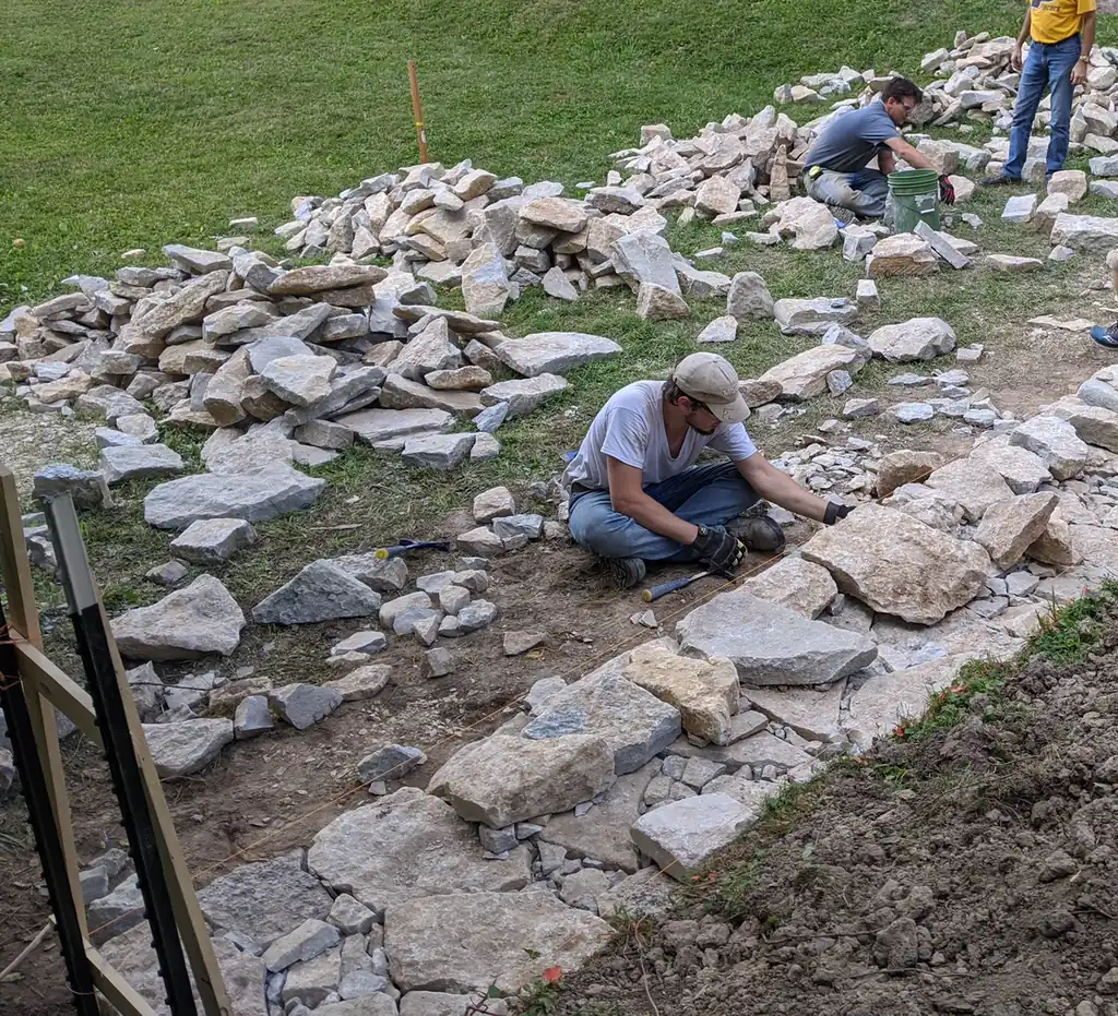 Alpine Landscaping crew building a dry-stack natural stone retaining wall in Nashville, TN
