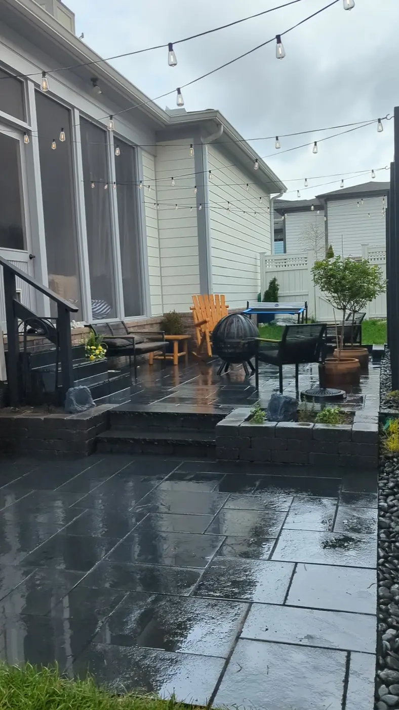 Dark paver patio with string lights behind a home with a screened porch in Nashville, TN