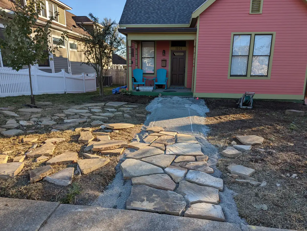 Flagstone front walkway being set in front of a coral bungalow in Nashville, TN