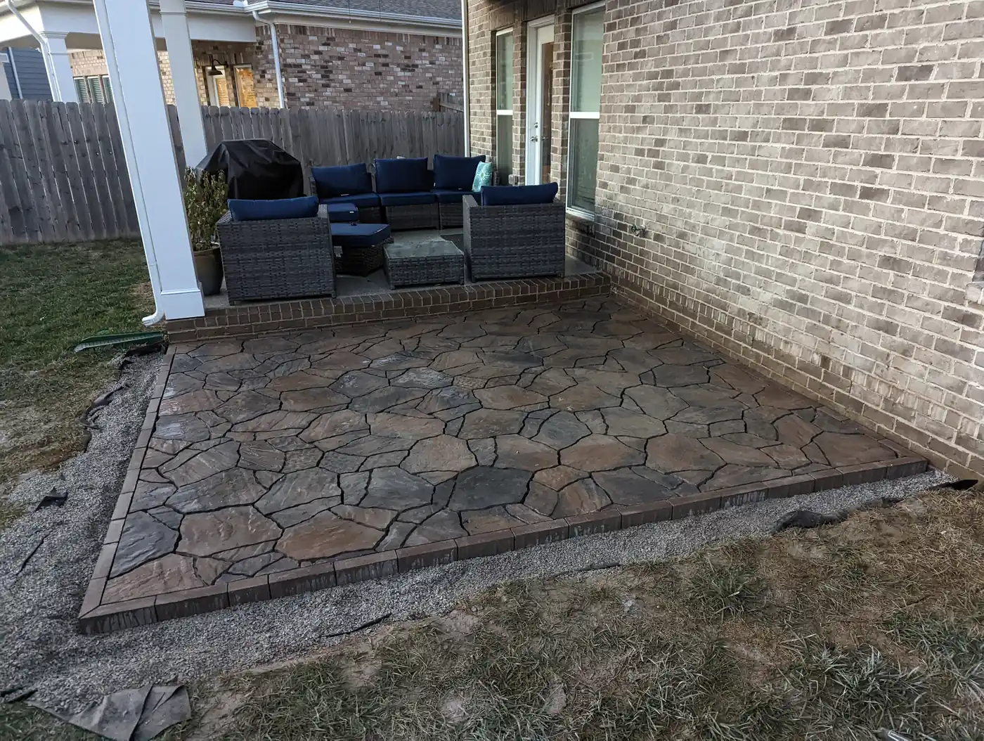Flagstone-look paver patio with sectional seating beside a brick home in Nashville, TN