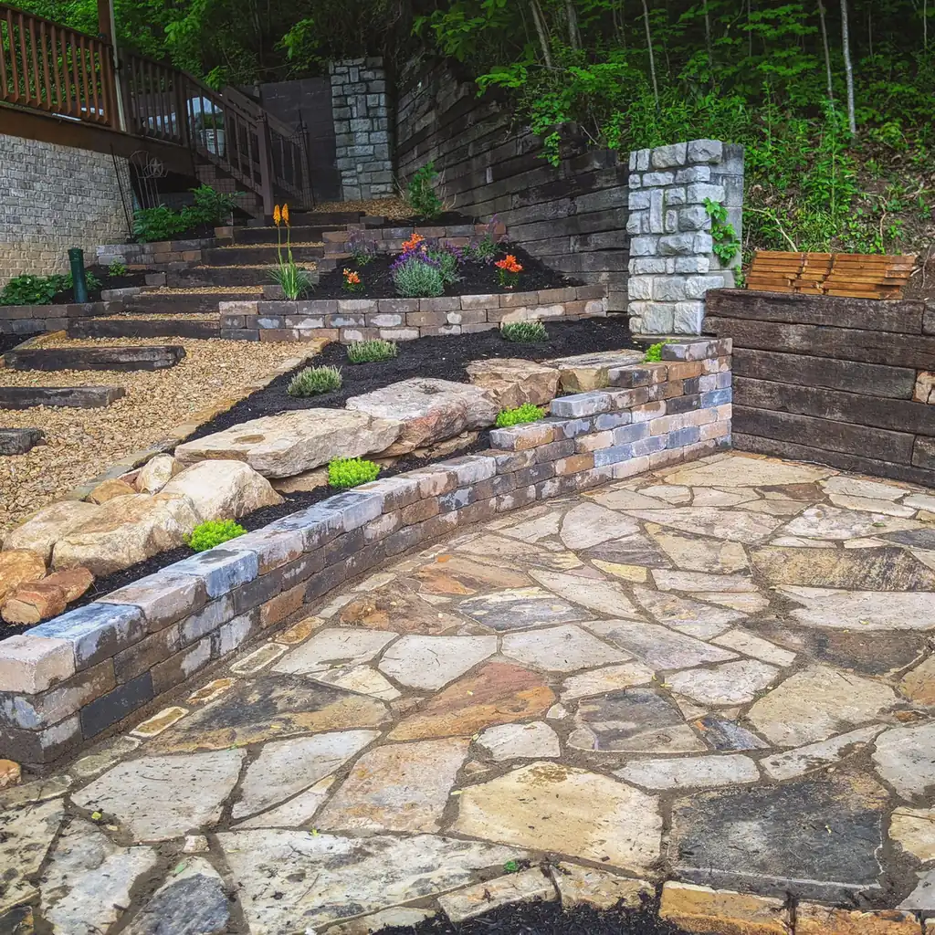 Flagstone patio with stacked stone planter walls, steps and spring tulips in Nashville, TN