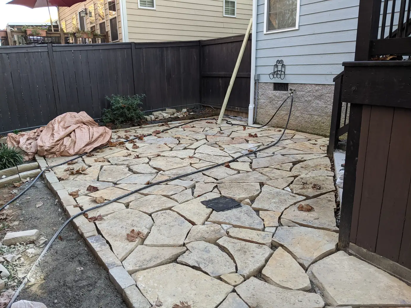 Natural flagstone patio being laid in a fenced backyard in Nashville, TN