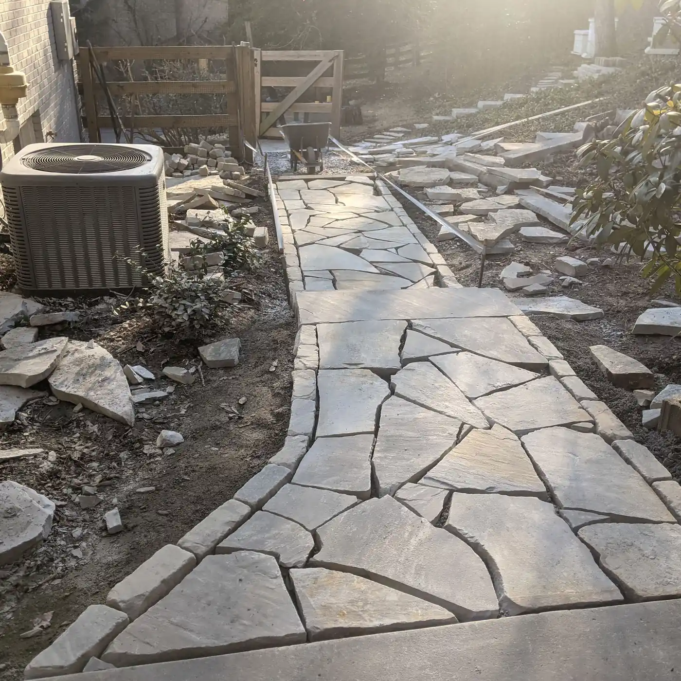 Flagstone walkway being fitted through a side yard beside the AC unit in Nashville, TN