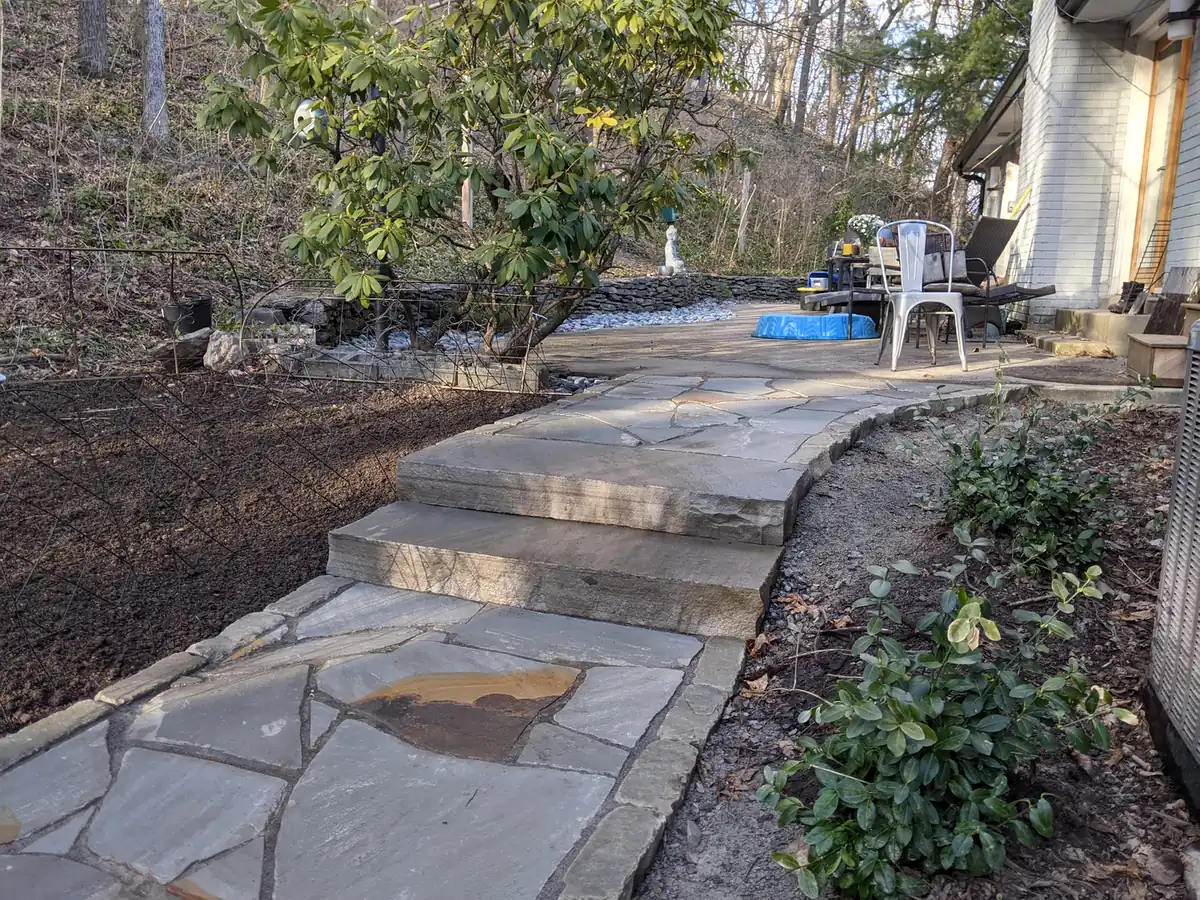 Flagstone walkway and stone steps climbing a wooded backyard slope in Nashville, TN