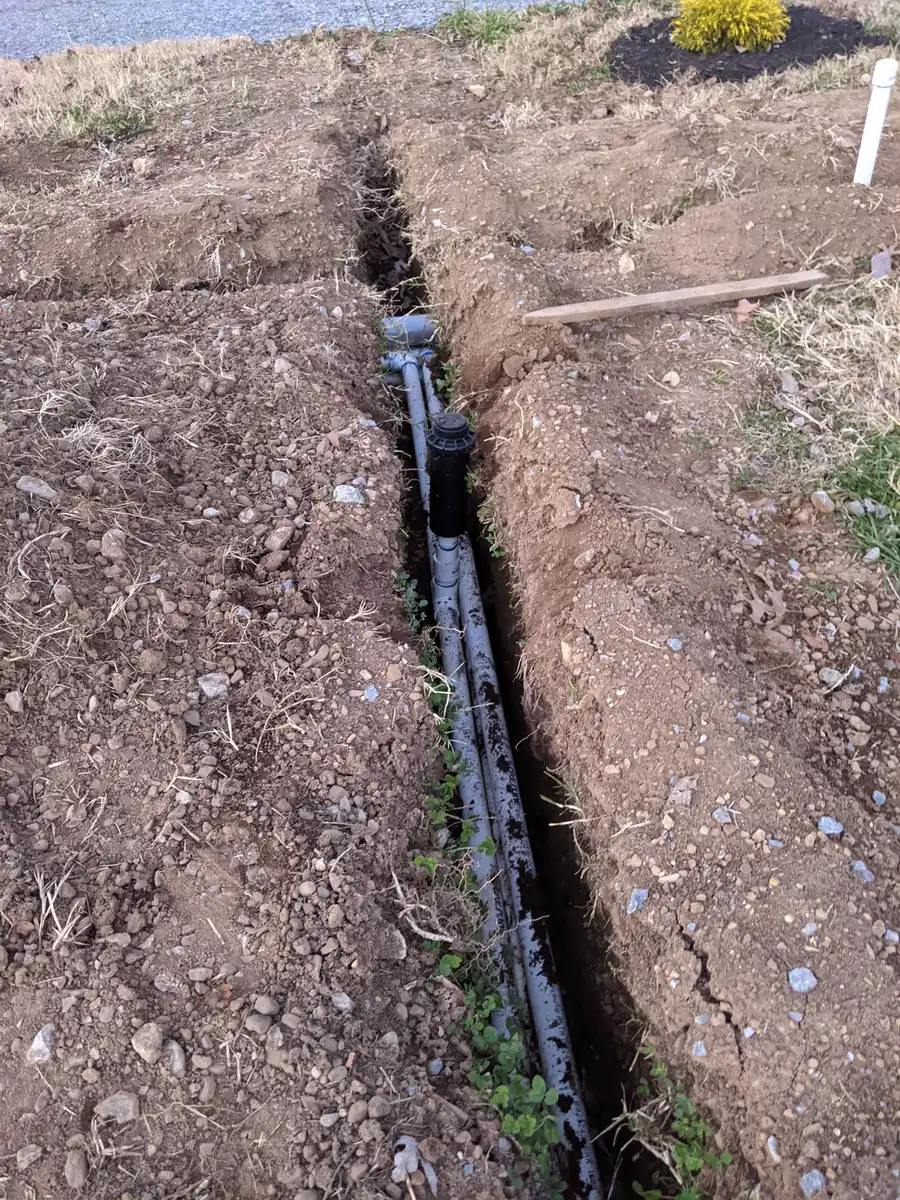 Trench with irrigation pipe laid across a bare-soil yard during installation in Nashville, TN