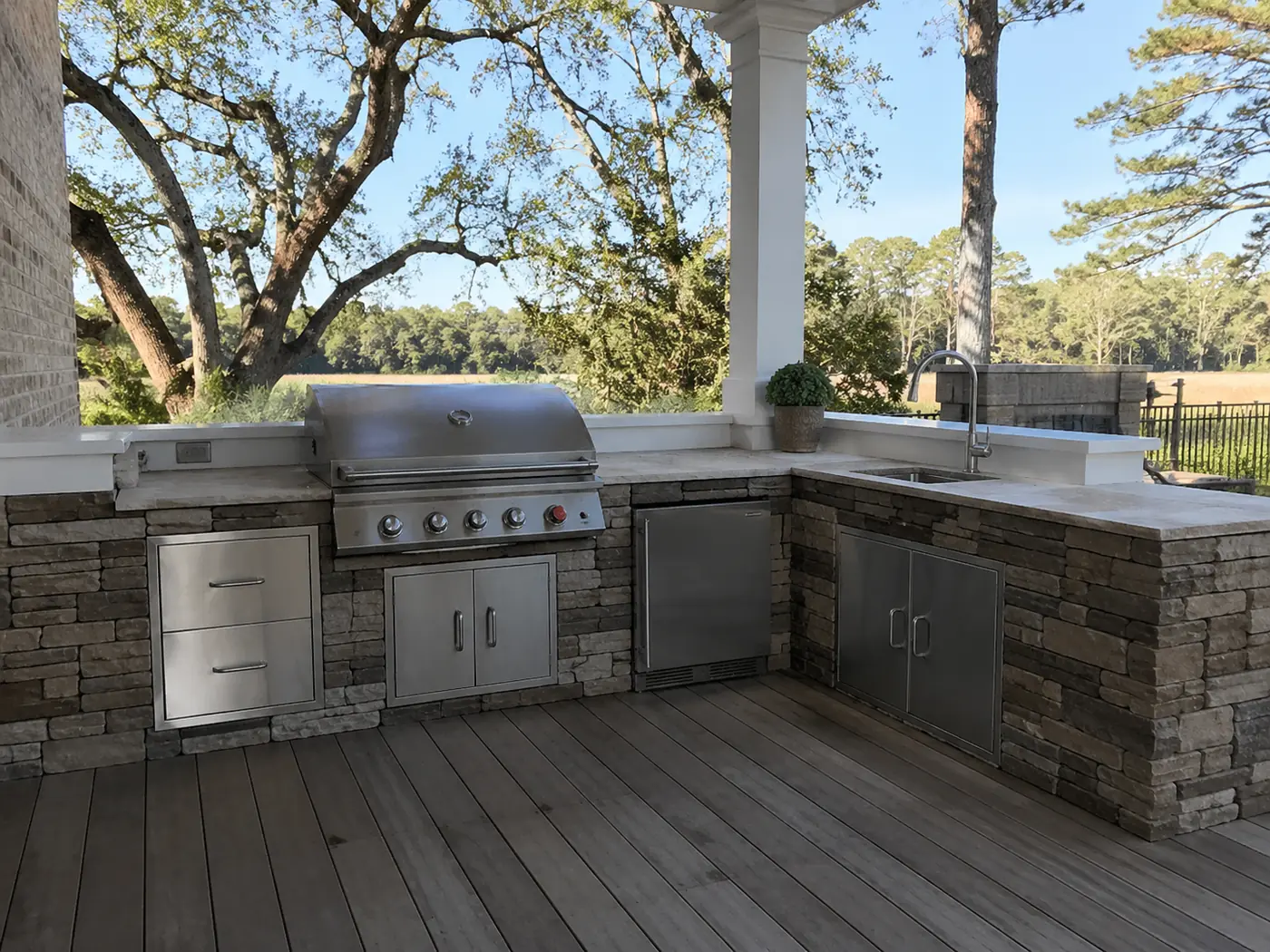 L-shaped stone outdoor kitchen on a covered deck in Nashville, TN