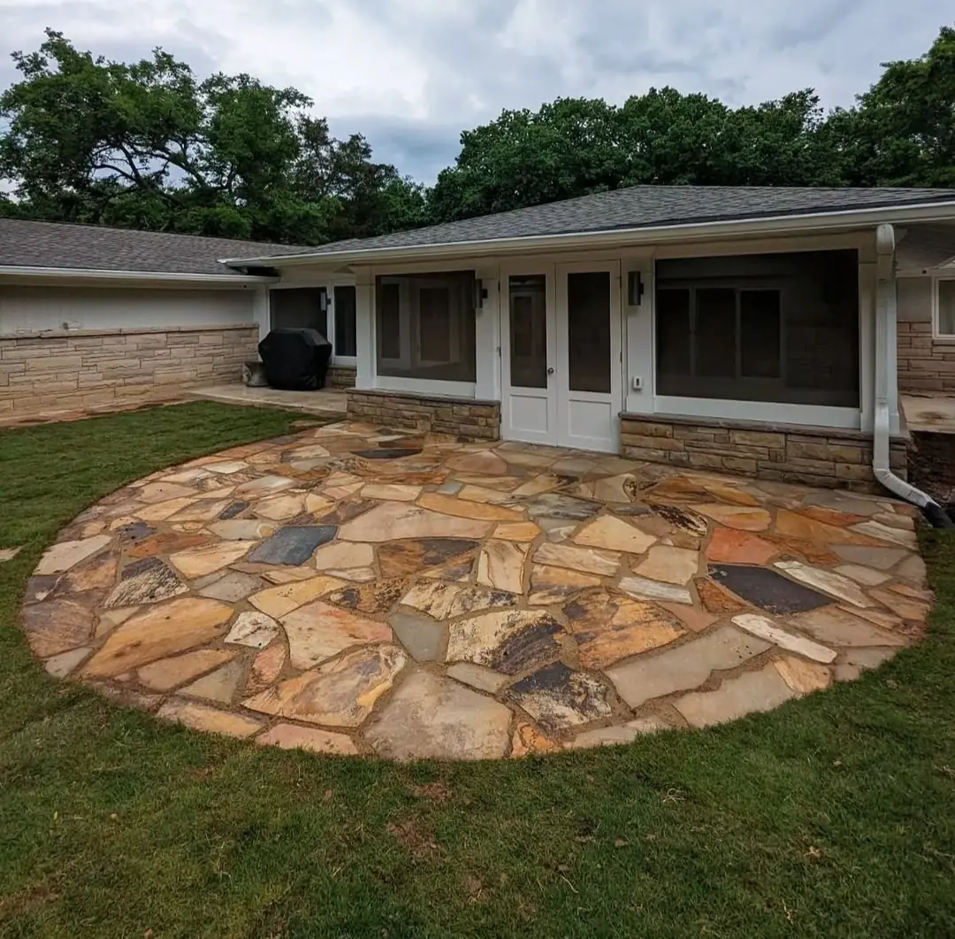 Large circular flagstone patio built behind a brick ranch home in Nashville, TN