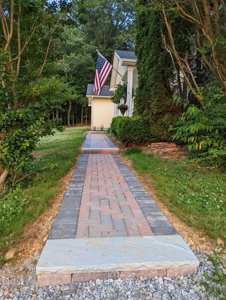 Long paver walkway with brick border through a shaded yard to a home in Nashville, TN