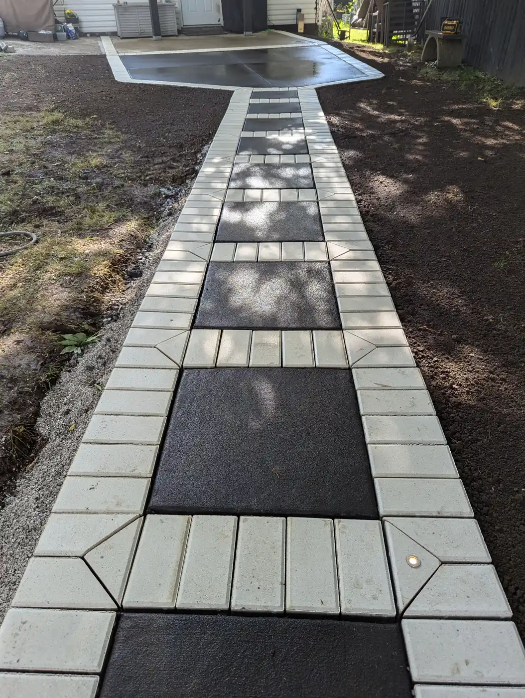 Modern paver walkway with dark inset panels along a home in Nashville, TN