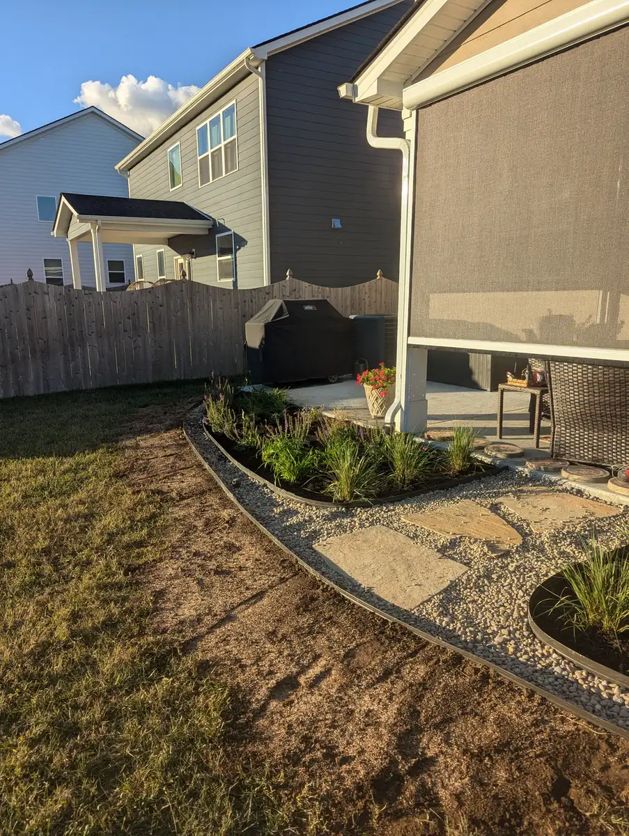 New shrub bed with rock edging beside a screened porch in Nashville, TN
