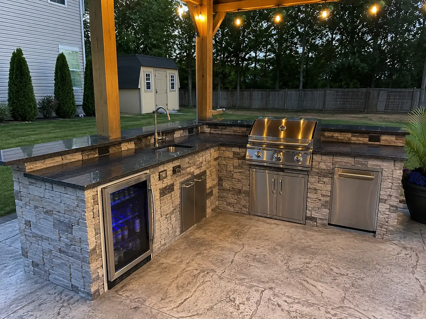 Outdoor kitchen with beverage fridge and string lights in the evening in Nashville, TN