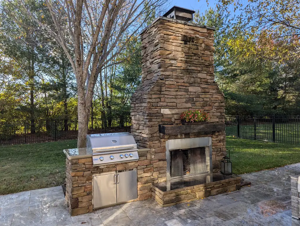 Outdoor stacked stone fireplace with a built-in stainless grill station in Nashville, TN