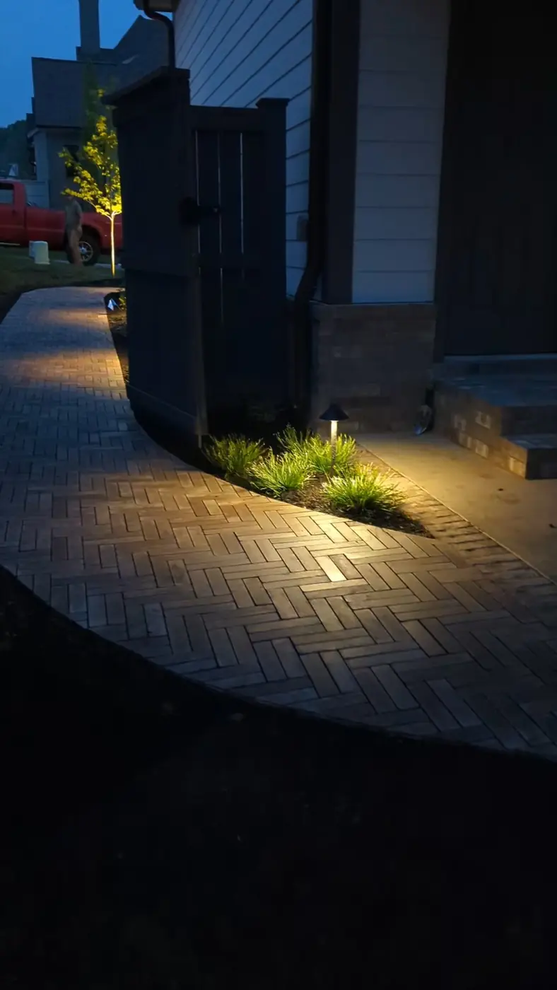 Path light glowing over a paver walkway and groundcover at night in Nashville, TN