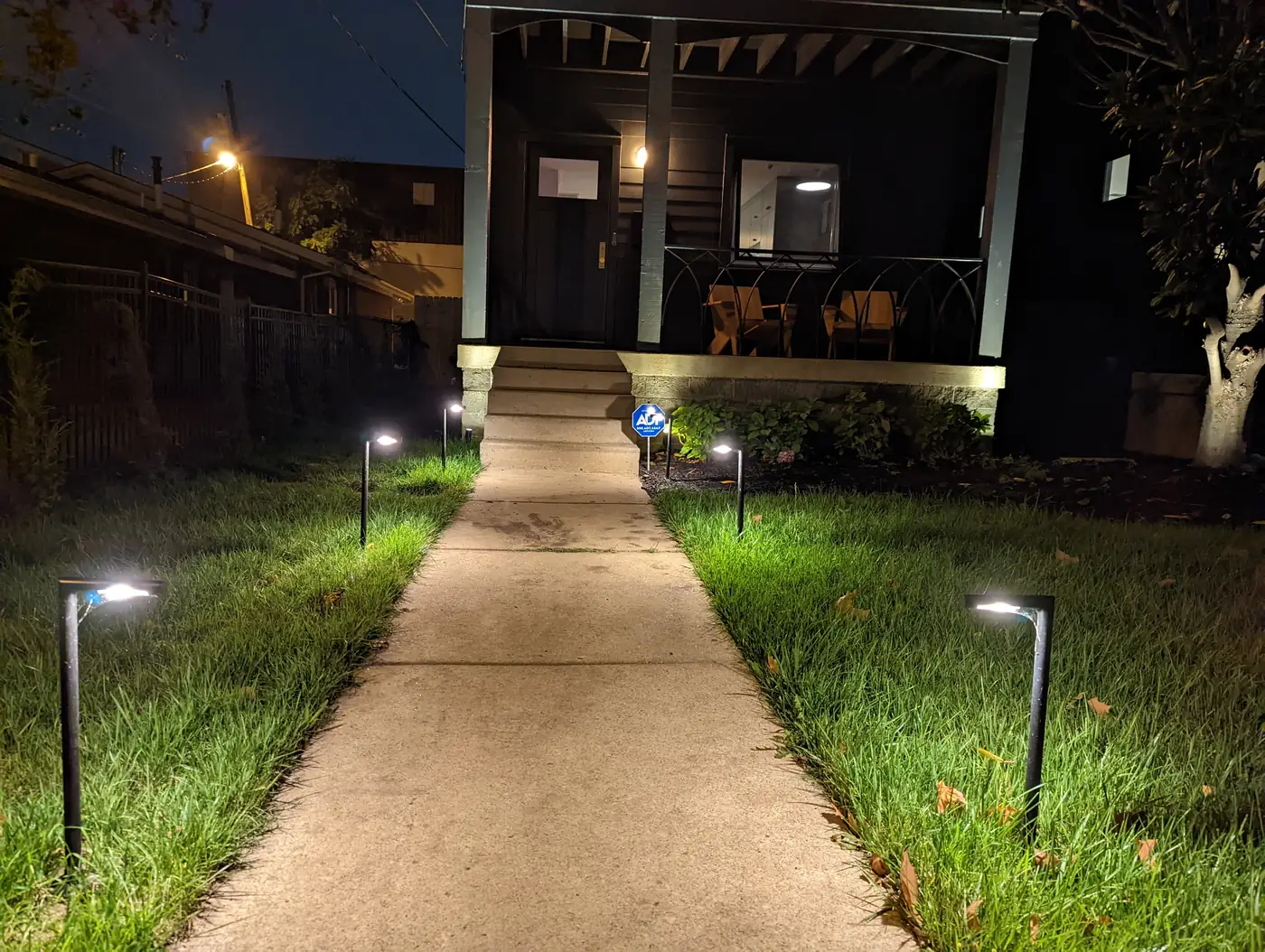 Low-voltage path lights lining a concrete walkway to a porch at night in Nashville, TN