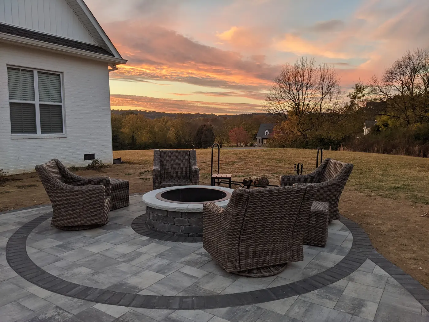 Paver patio with a block fire pit and wicker seating at sunset in Nashville, TN