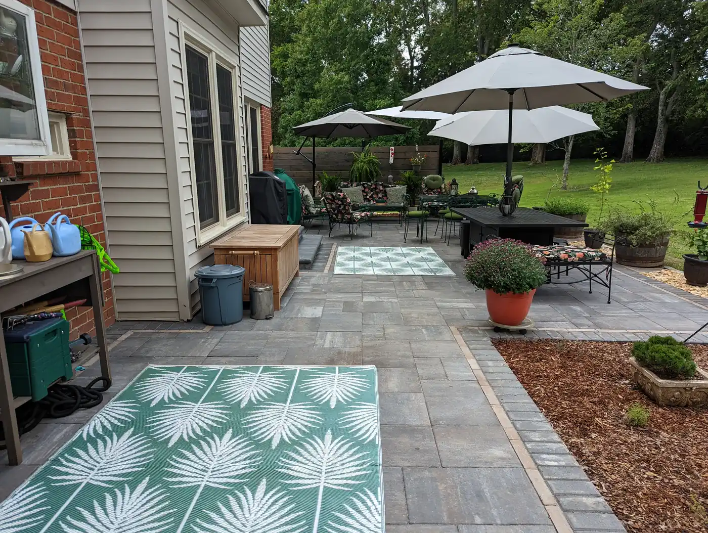 Paver patio with outdoor dining set and umbrella behind a brick home in Nashville, TN