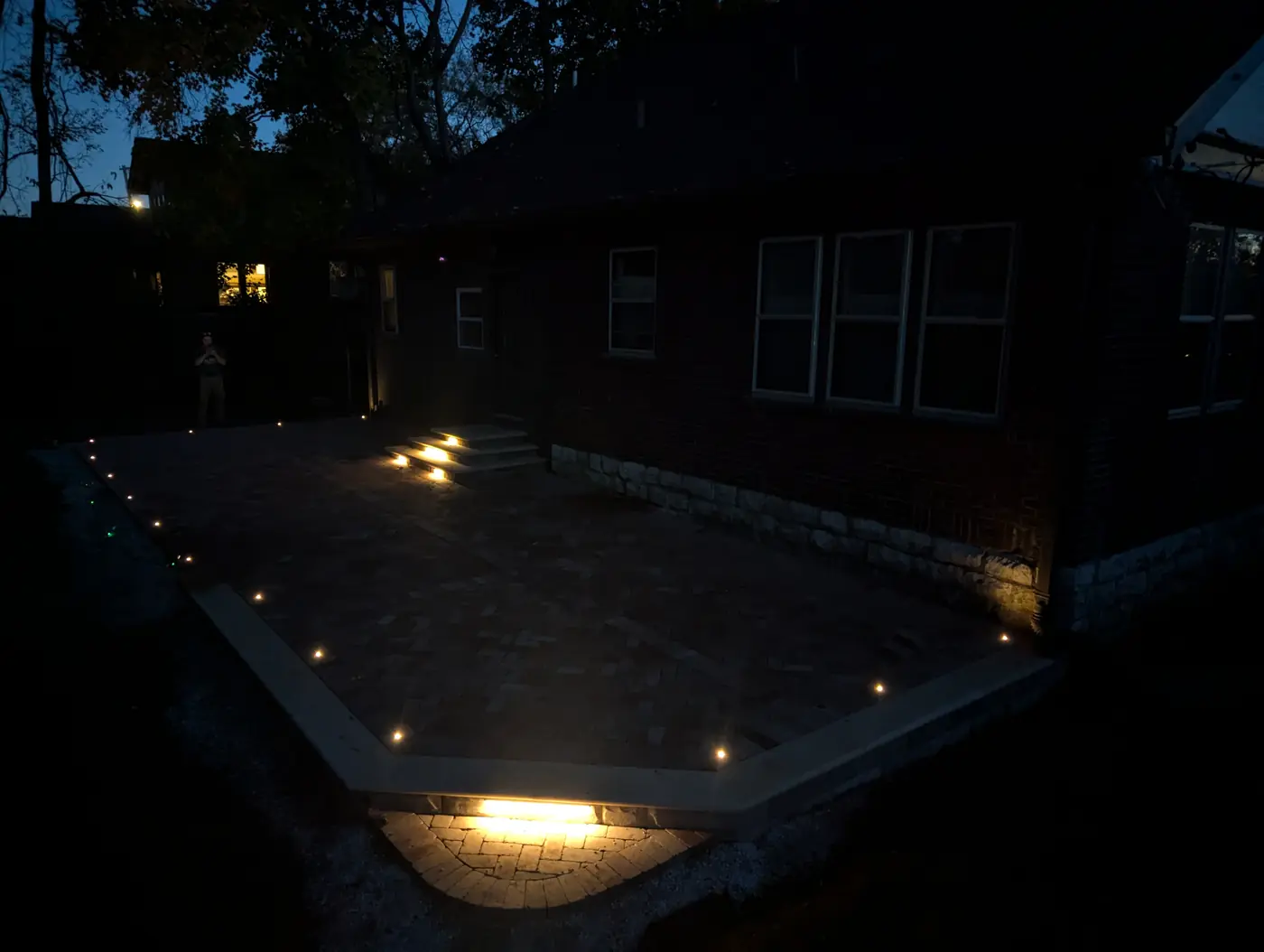 Paver patio with in-wall step lights behind a home at night in Nashville, TN