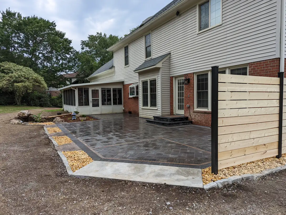 Paver patio with tan border and horizontal wood privacy screen at a brick home in Nashville, TN