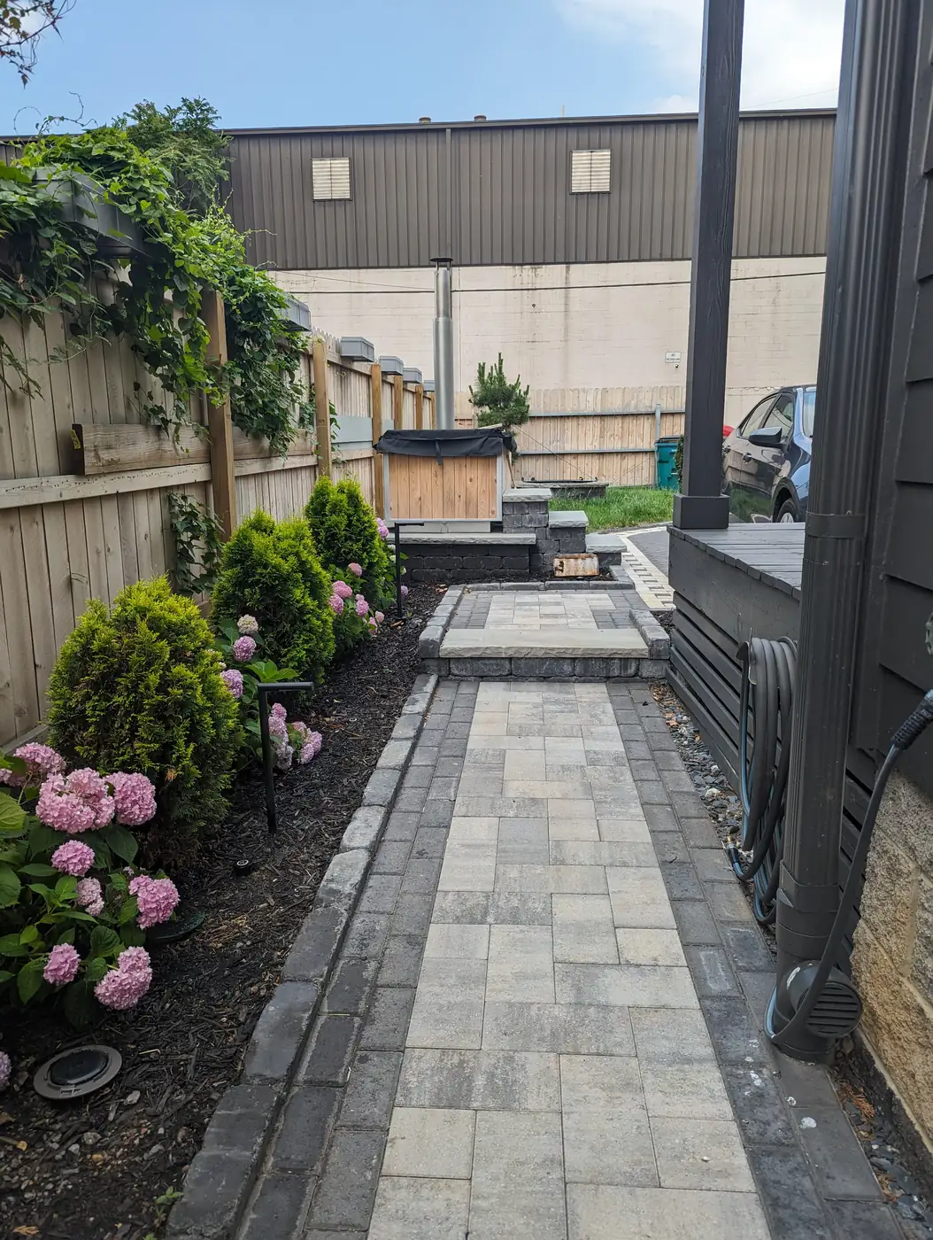 Paver side-yard walkway lined with hydrangeas and evergreens in Nashville, TN