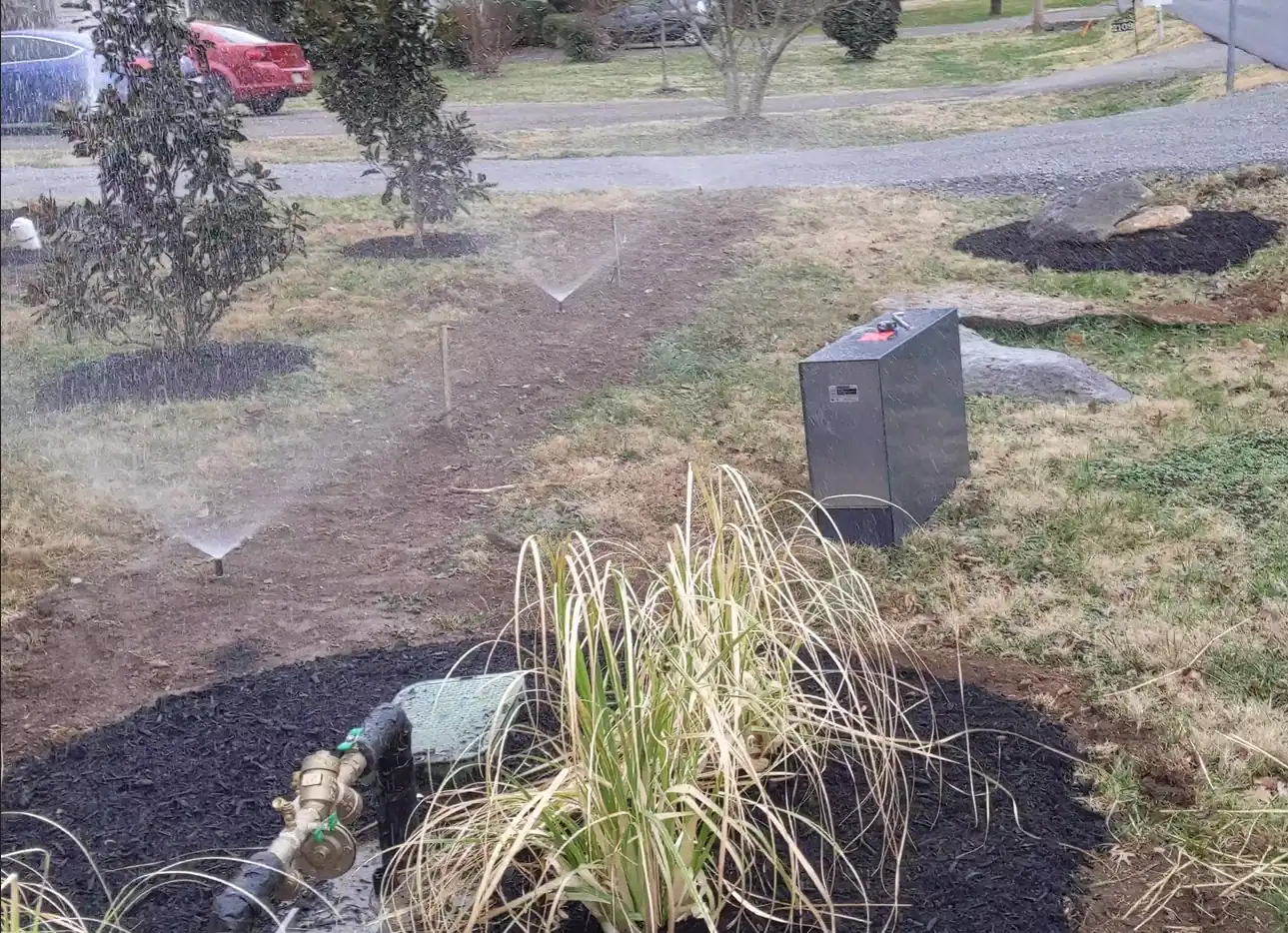 Sprinkler heads watering freshly mulched landscape beds in Nashville, TN
