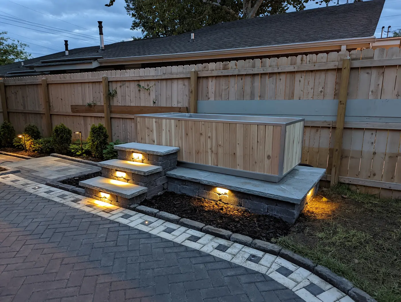 Seat wall step lights over a paver walkway at dusk in Nashville, TN
